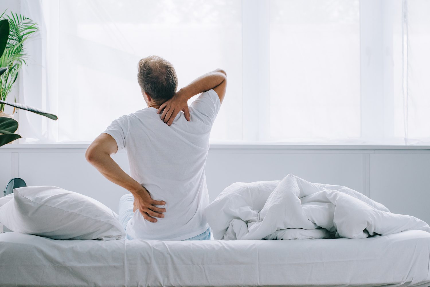 man with back pain waking up